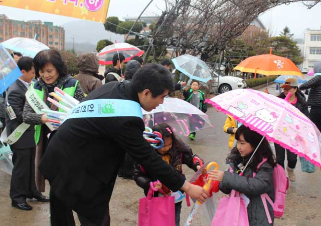 경주시는 제192차 안전점검의날을 맞이해 경주흥무초등학교서 안전용품(우산) 나눠주고 있다.