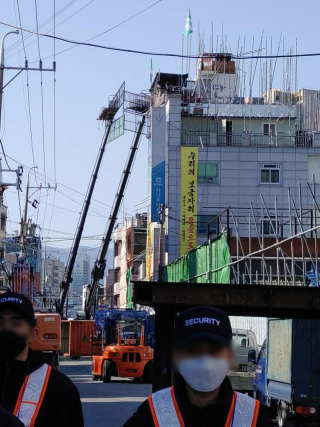 대구 동인3-1지구 주택재개발정비사업 강제철거 현장에서 크레인과 공사 장비, 용역업체 직원 등이 보인다. 강제철거 대상 건물에 