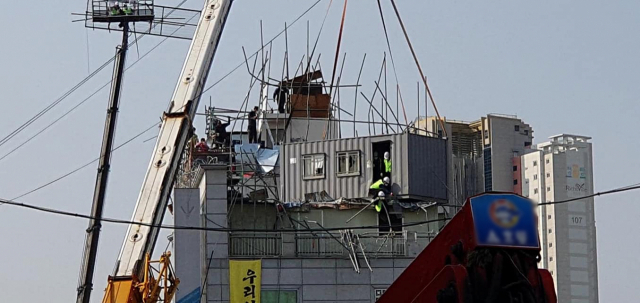 지난 25일 대구 동인3-1지구 주택재개발정비사업 강제철거 현장에서 대구지법 강제집행관들이 크레인에 매단 컨테이너에 탄 채 건물 옥상 진입을 시도하고 있다. 전국철거민연합회 제공