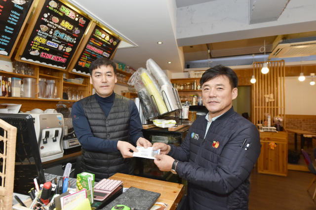 윤경희 청송군수가 청송사랑화폐를 사용해 지역 내 커피숍에서 음료를 주문하고 기념촬영을 하고 있다. 청송군 제공