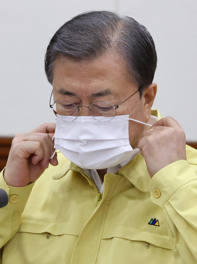 문재인 대통령이 13일 오후 정부서울청사에서 열린 신종 코로나바이러스 감염증(코로나19) 대응 긴급 중앙재난안전대책본부(중대본) 회의에 참석, 발언에 앞서 마스크를 벗고 있다. 연합뉴스