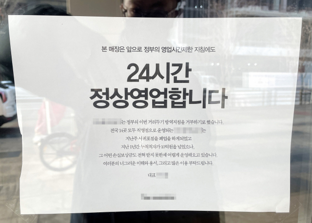 신종 코로나바이러스 감염증(코로나19) 확산으로 전국에 강화된 방역 조치가 시행 중인 가운데 21일 오전 인천 한 카페 출입문에 정부 영업제한 조치를 거부하고 24시간 영업을 강행한다는 내용의 안내문이 부착돼 있다. 연합뉴스
