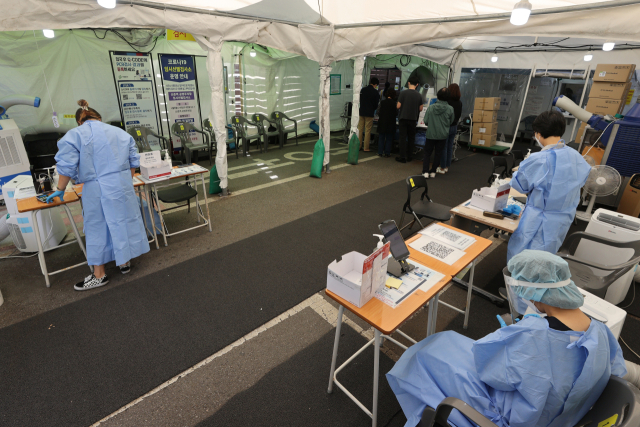 코로나19 재유행이 감소세를 보이는 가운데 21일 오전 의료진들이 한산한 서울 서대문구 보건소 선별진료소에서 대기하고 있다. 중앙방역대책본부에 따르면 이날 0시 기준 신규확진자는 4만1286명으로 전날보다 6천631명 줄어들었다. 연합뉴스