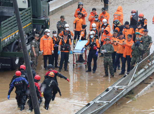16일 미호천 제방 유실로 침수된 충북 청주시 오송읍 궁평2지하차도에서 119 구조대원들이 시신으로 발견된 실종자를 수습하고 있다. 연합뉴스