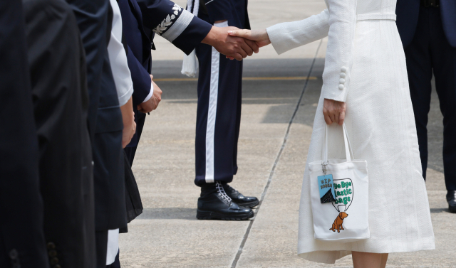 윤석열 대통령과 함께 리투아니아에서 열리는 북대서양조약기구(NATO.나토) 정상회의 참석과 폴란드 방문에 나서는 김건희 여사가 10일 성남 서울공항에 도착, 환송객들과 인사하고 있다. 김 여사는 이날 바이바이 플라스틱 백이라는 문구가 적힌 에코백에 힙 코리아(HIP KOREA)라고 적힌 키링(열쇠고리)을 매달았다. 연합뉴스
