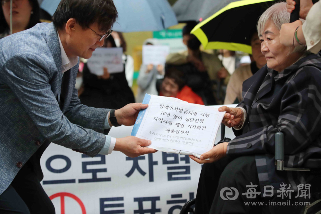 15일 국가인권위원회 대구인권사무소 앞에서 열린 장애인차별금지법 시행 16년 맞이 집단진정 및 제언 기자회견에서 박명애(오른쪽) 420장애인차별철폐대구투쟁연대 상임공동대표가 정연걸 대구인권사무소장에게 진정서를 전달하고 있다. 정운철 기자 woon@imaeil.com